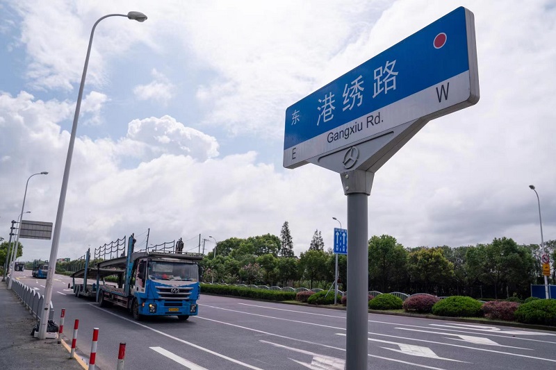 华东路-申东路口东约30米,来自安徽的集卡司机袁师傅正在保养自已那辆